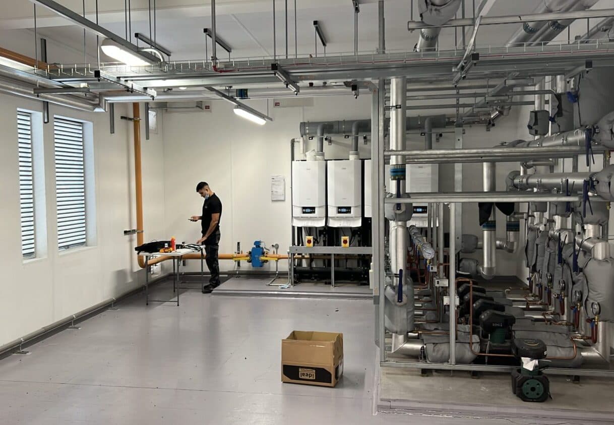 Engineer commissioning Ideal commercial boilers in a large plant room