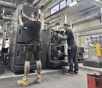 Two Spitfire Commercial engineers working on a large commercial boiler in a plant room