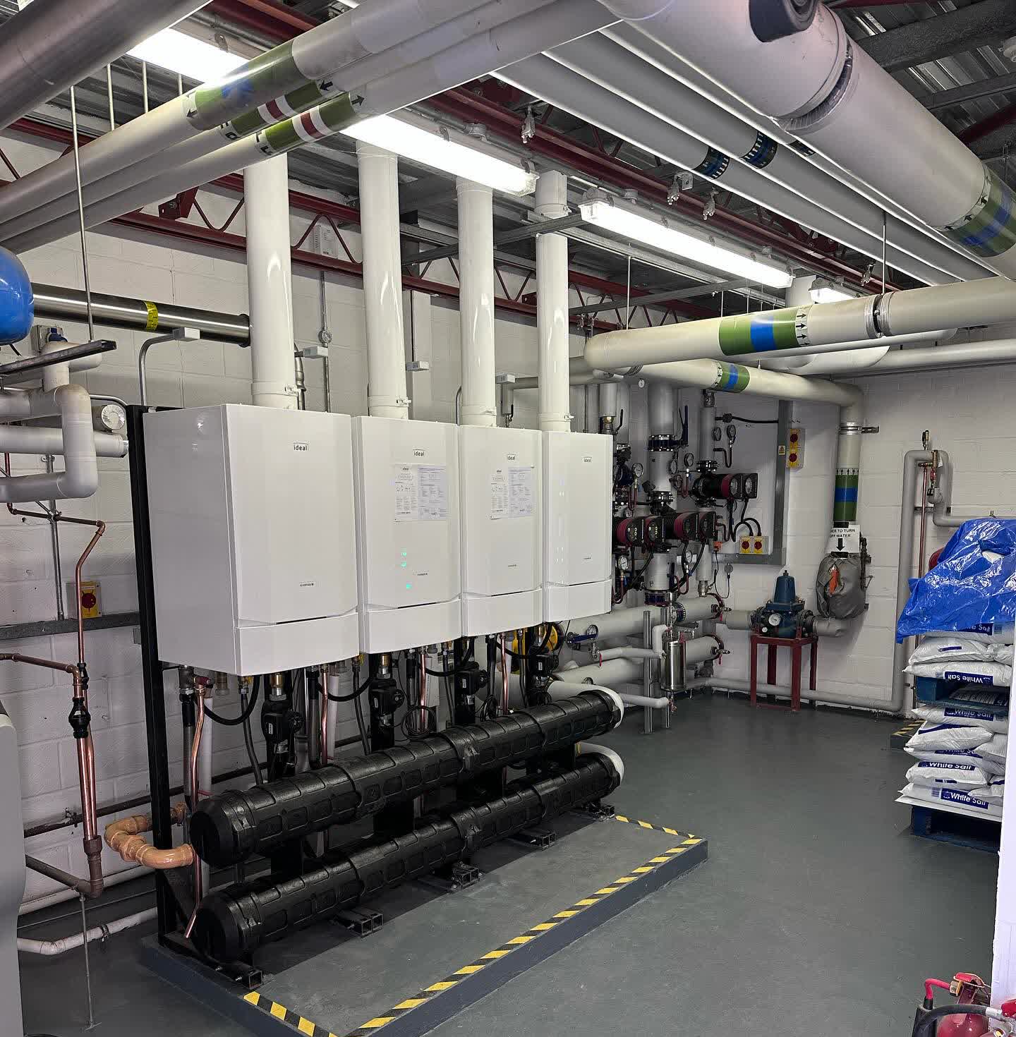 Portchester plant room after the rebuild: four-boiler Ideal wall-hung cascade with new pumps