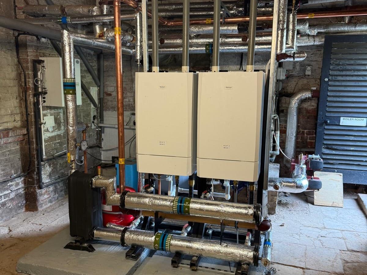 Care home boiler room with two Keston Heat 2 boilers on a plinth, insulated headers and a plate heat exchanger