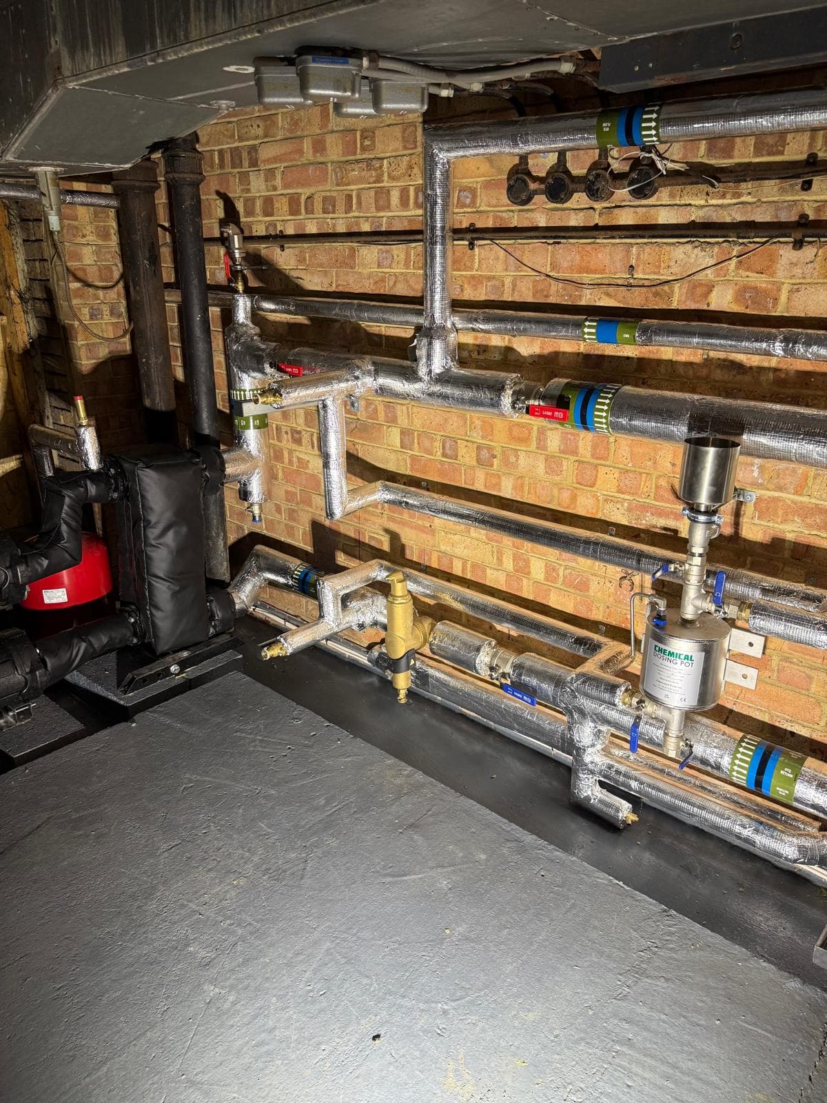 Chemical dosing pot and insulated distribution pipework in the synagogue plant room