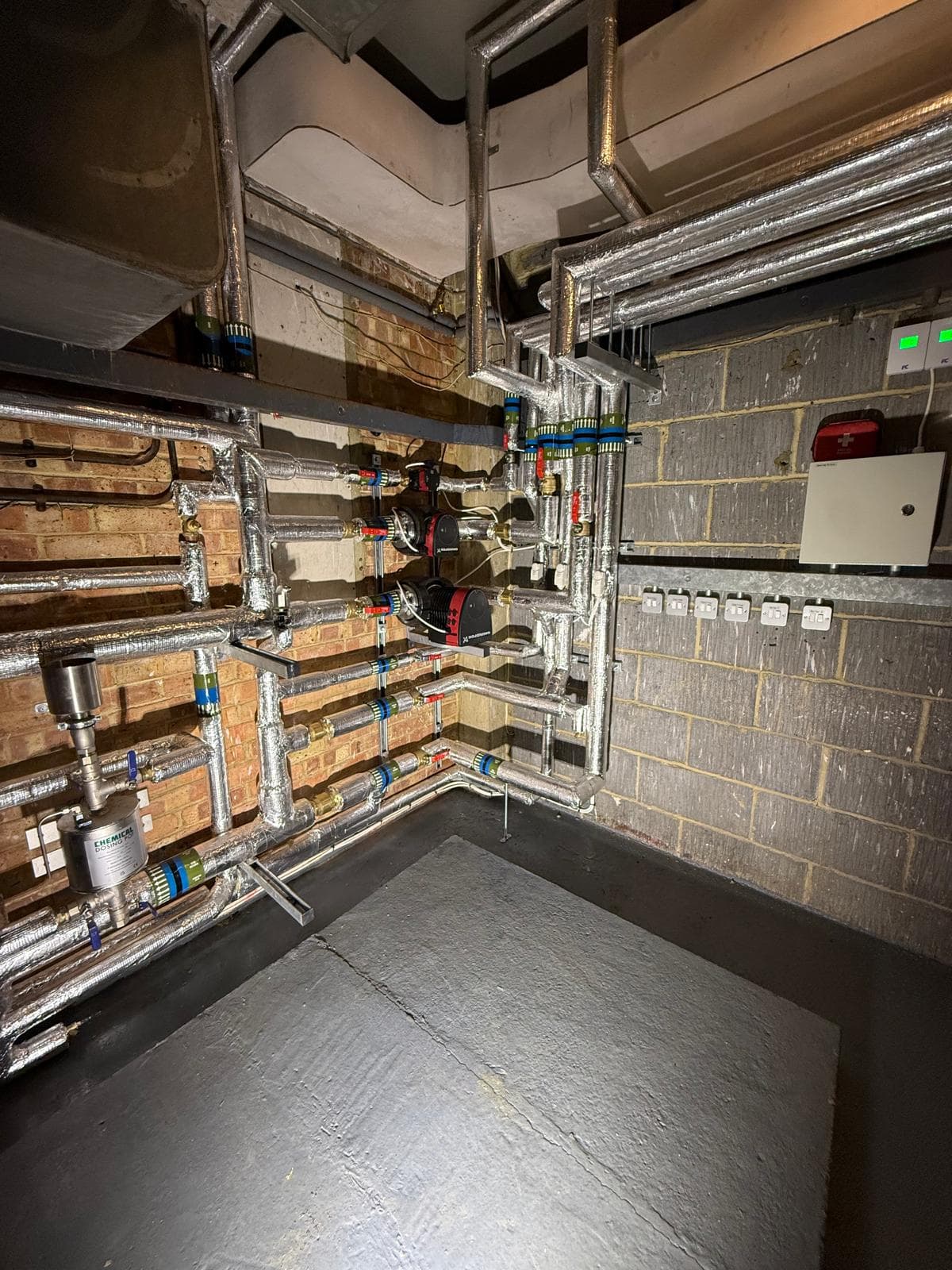 Pump and distribution wall with twin Grundfos pumps, dosing pot and dirt separator, every circuit labelled